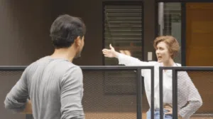 Una donna che discute animatamente con un suo vicino di casa