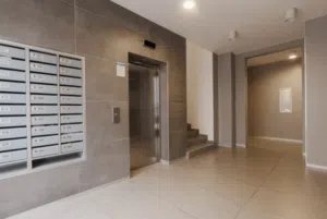 Entrata di un condominio con le cassette postali, un'ascensore e le scale